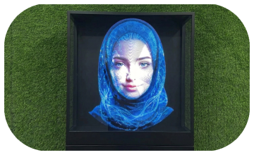 AI kiosk at an event features a digital display of a ai hologram woman in a blue hijab